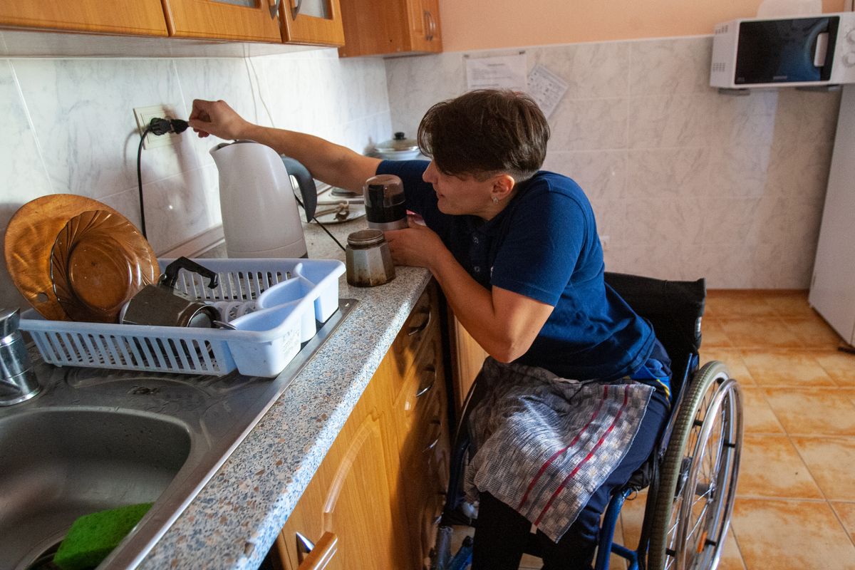 Wheelchair user preparing coffee in a kitchen